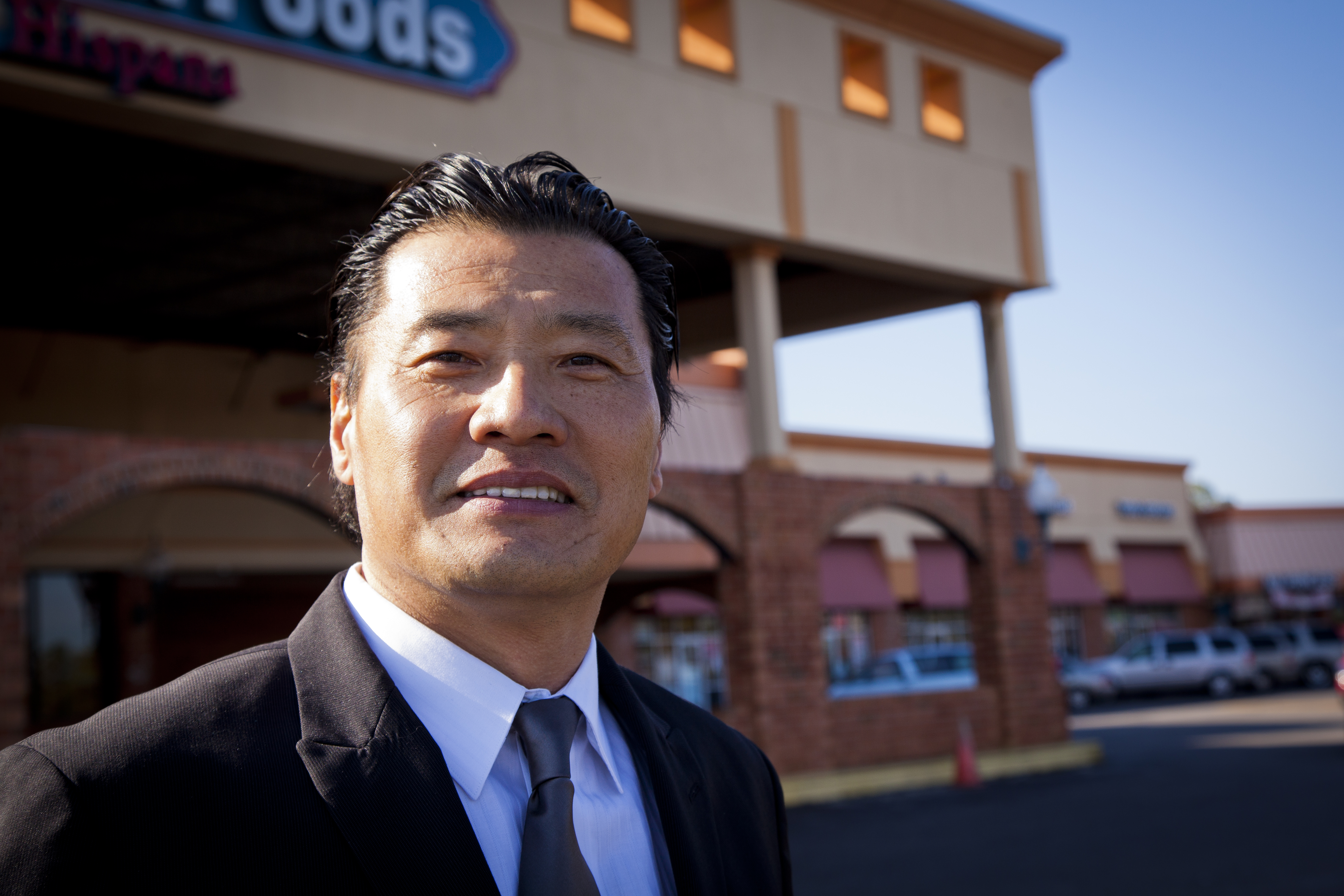 Asian man in a suit outside of a store