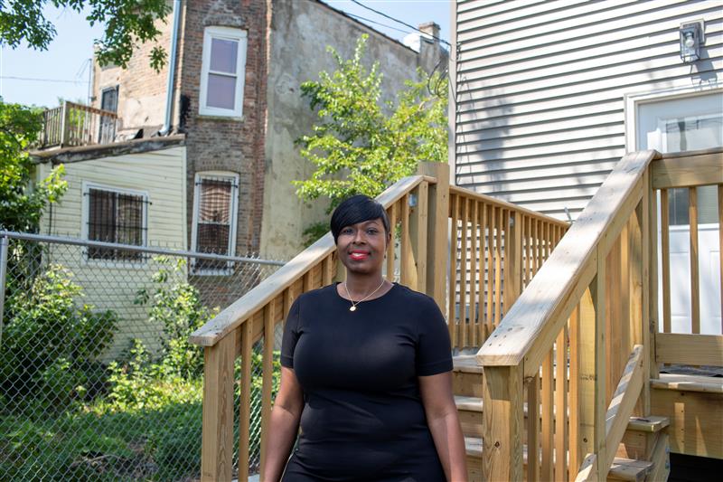 Self-Help borrower, Sanrena Howard, standing in front of a staircase